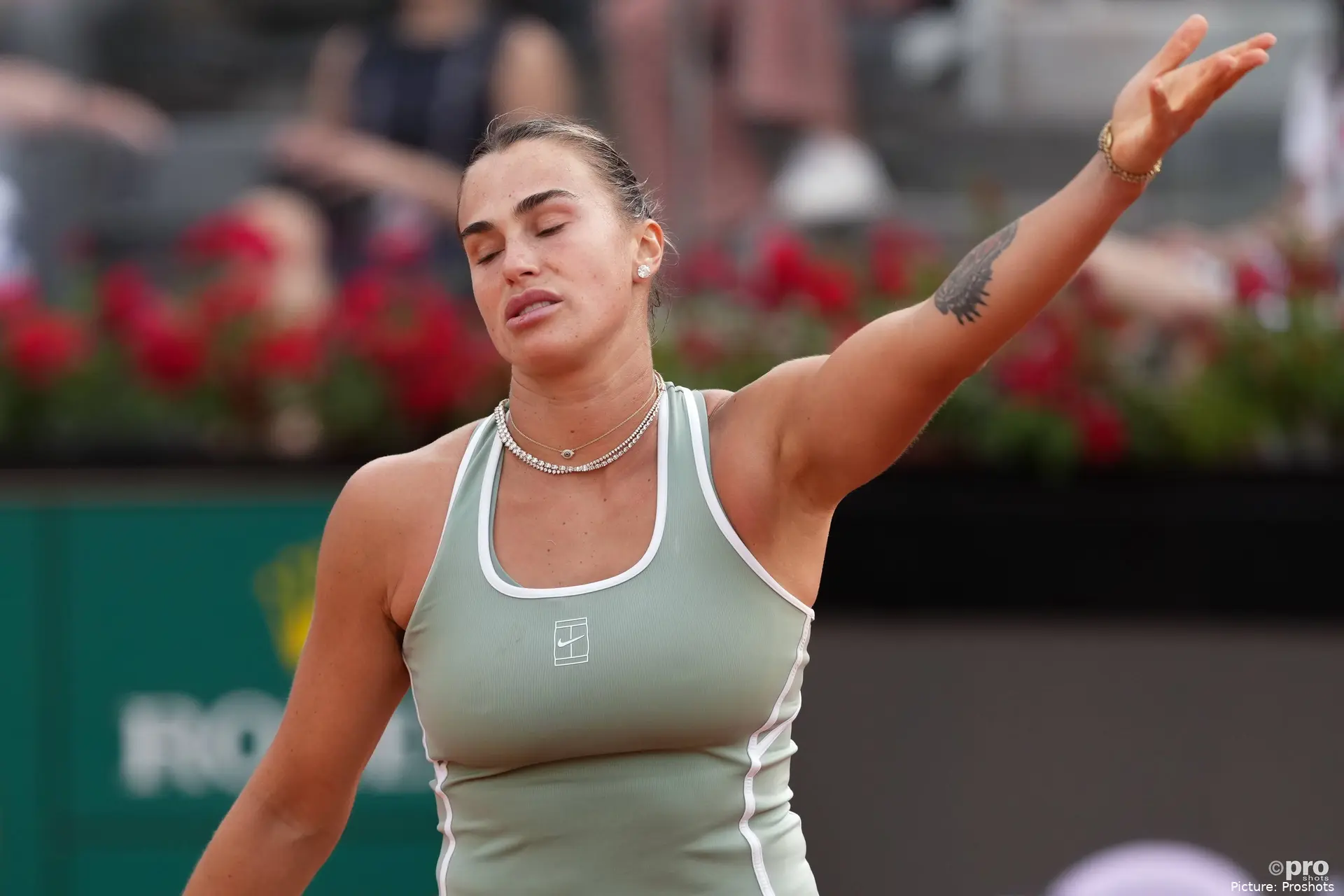 Aryna Sabalenka raises her arm in frustration