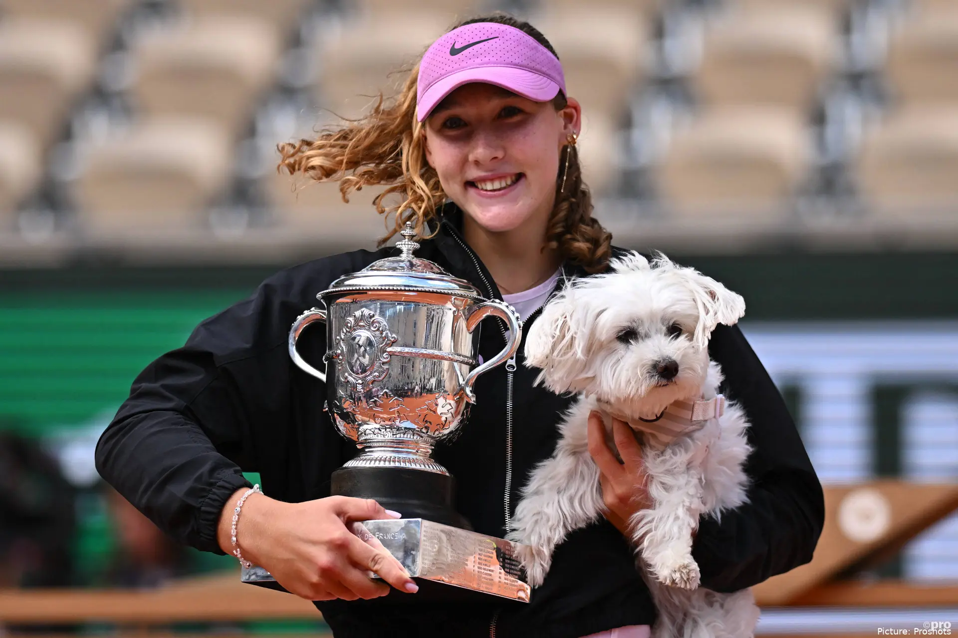 Mirra Andreeva holding the Roland Garros trophy and her dog