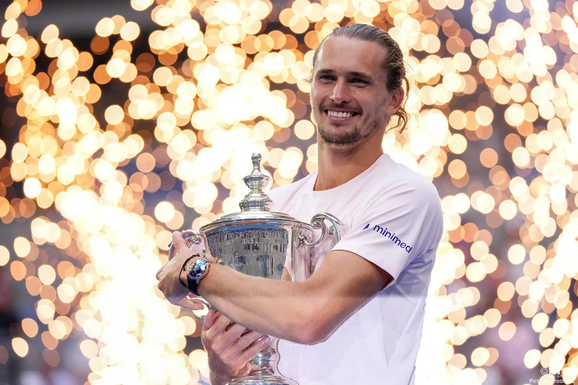Alexander Zverev holding a trophy while smiling