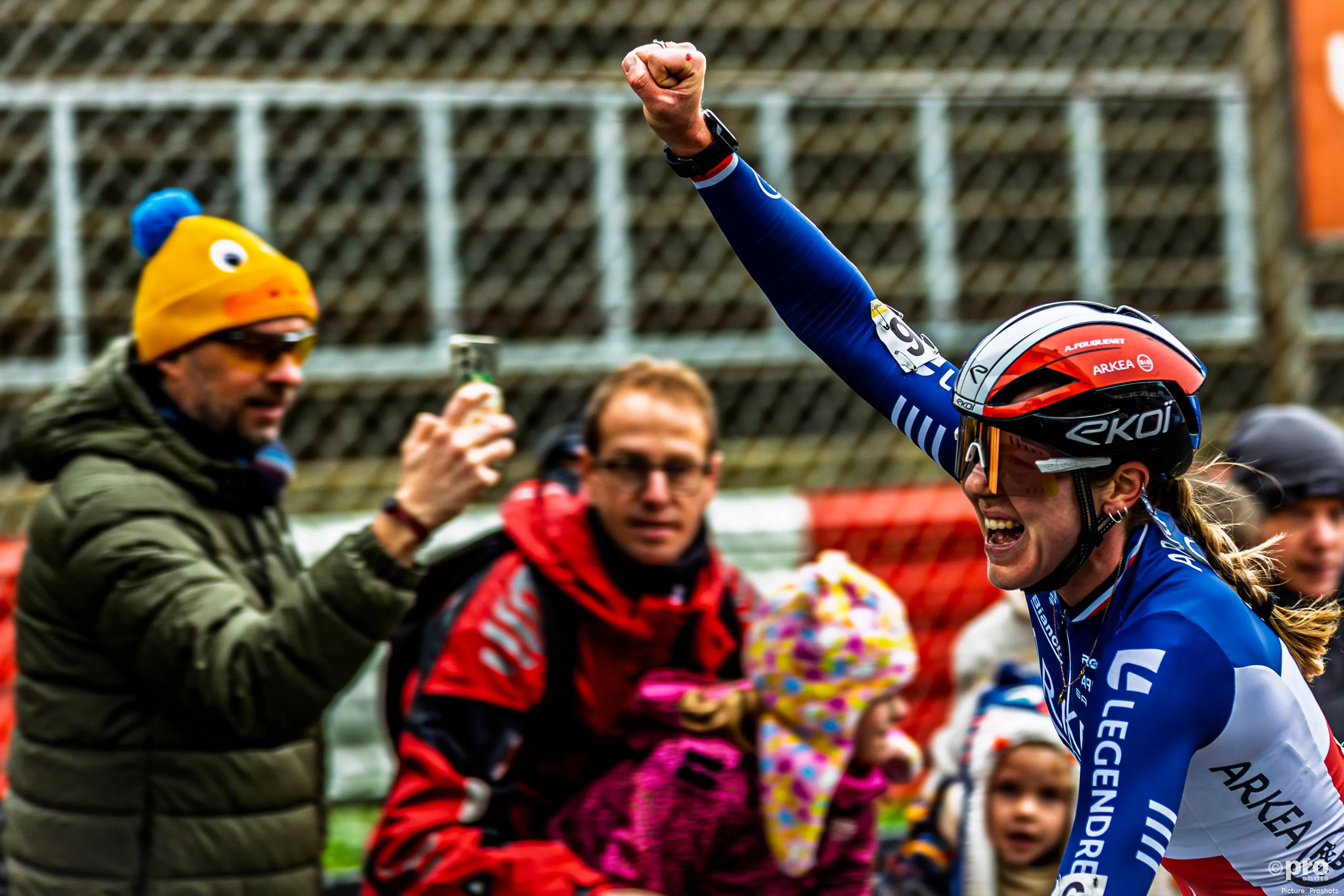 Amandine Fouquenet lifting her arm to celebrate a victory in a cyclocross race