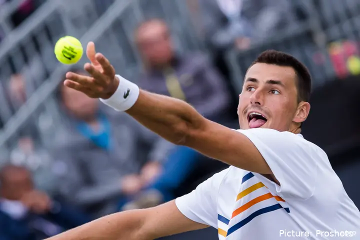 Tomic serves.