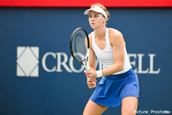 Samsonova holding the racket with both hands, awaits the ball from the back of the court.