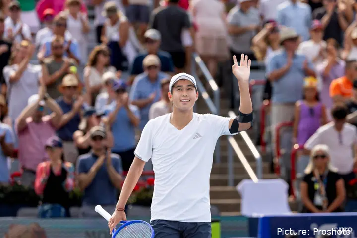 Learn Tien raises his hand to greet the audience with the crowd in the background