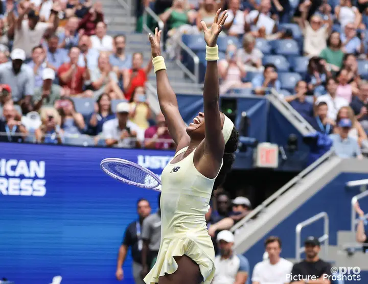 Coco Gauff raises her arms after defeating Mirra Andreeva in the US Open quarterfinals.