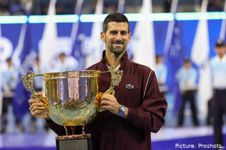 Novak Djokovic smiling while holding trophy