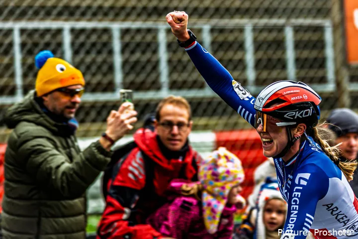 Amandine Fouquenet steekt juichend haar arm in de lucht na een zege in een veldrit