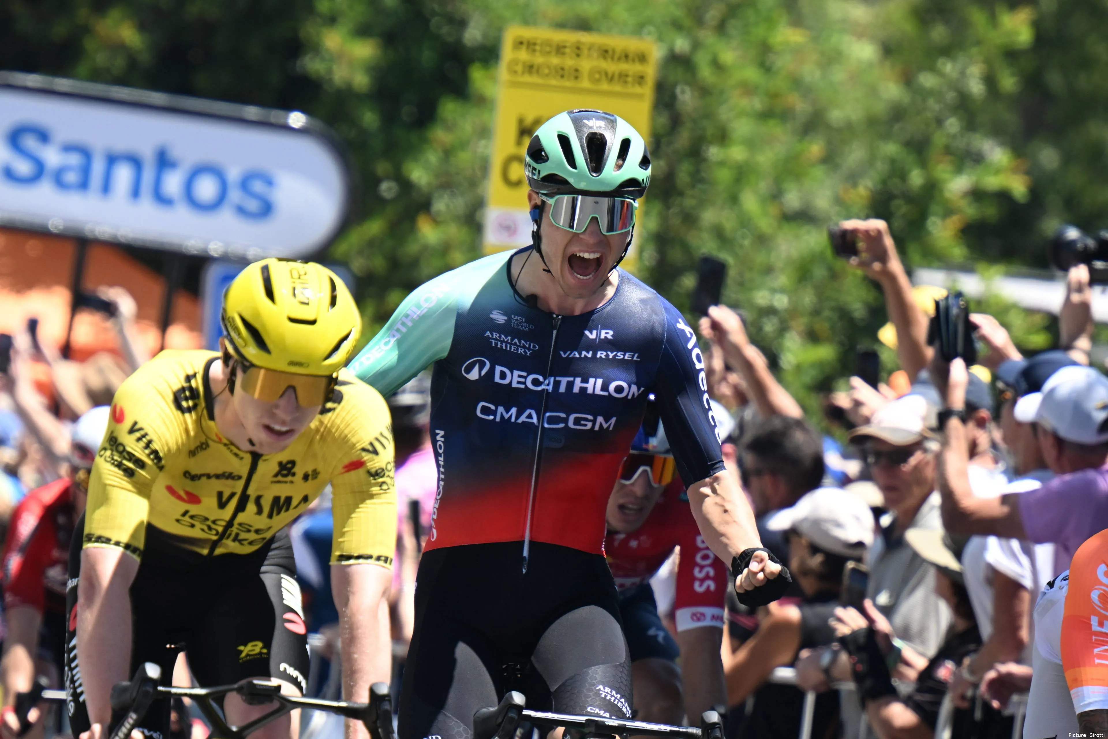 Tobias Lund Andresen steekt de armen omhoog na zijn winst in rit 1 van de Tour Down Under 2026