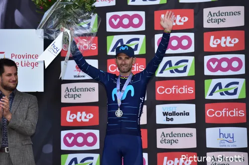 Alejandro Valverde steht mit erhobenen Armen auf dem Podium