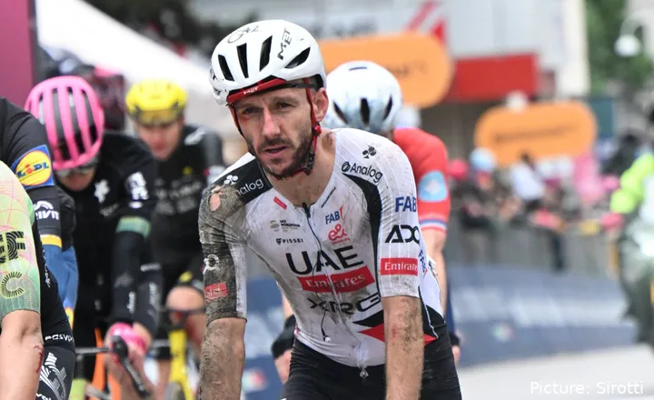 Ein blutüberströmter, schlammverschmierter Adam Yates überquert nach seinem Sturz auf der 2. Etappe des Giro d’Italia 2026 die Ziellinie