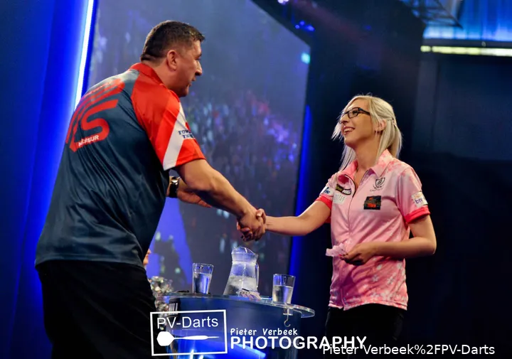 Fallon Sherrock and Mensur Suljovic shake hands on stage during the 2020 World Darts Championship