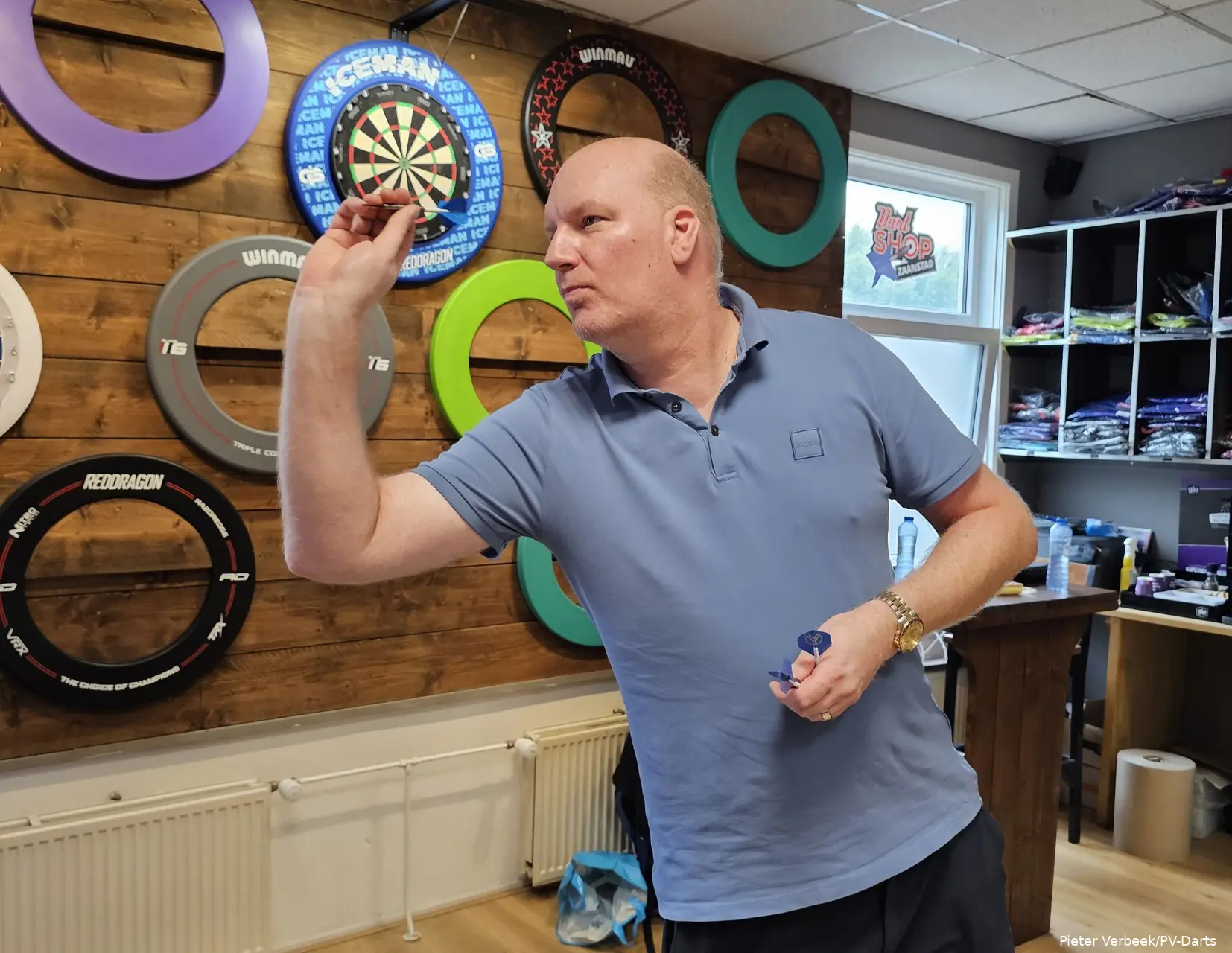 Vincent van der Voort wirft einen Dartpfeil in seinem eigenen Dartshop