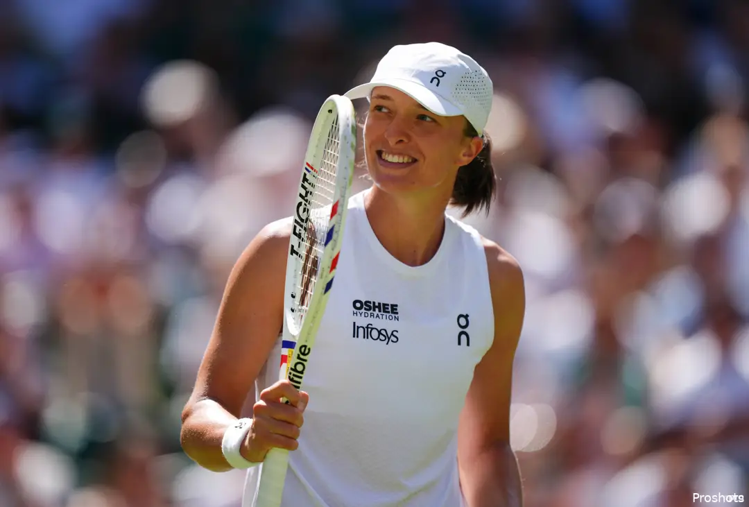 Iga Swiatek holds racquet.