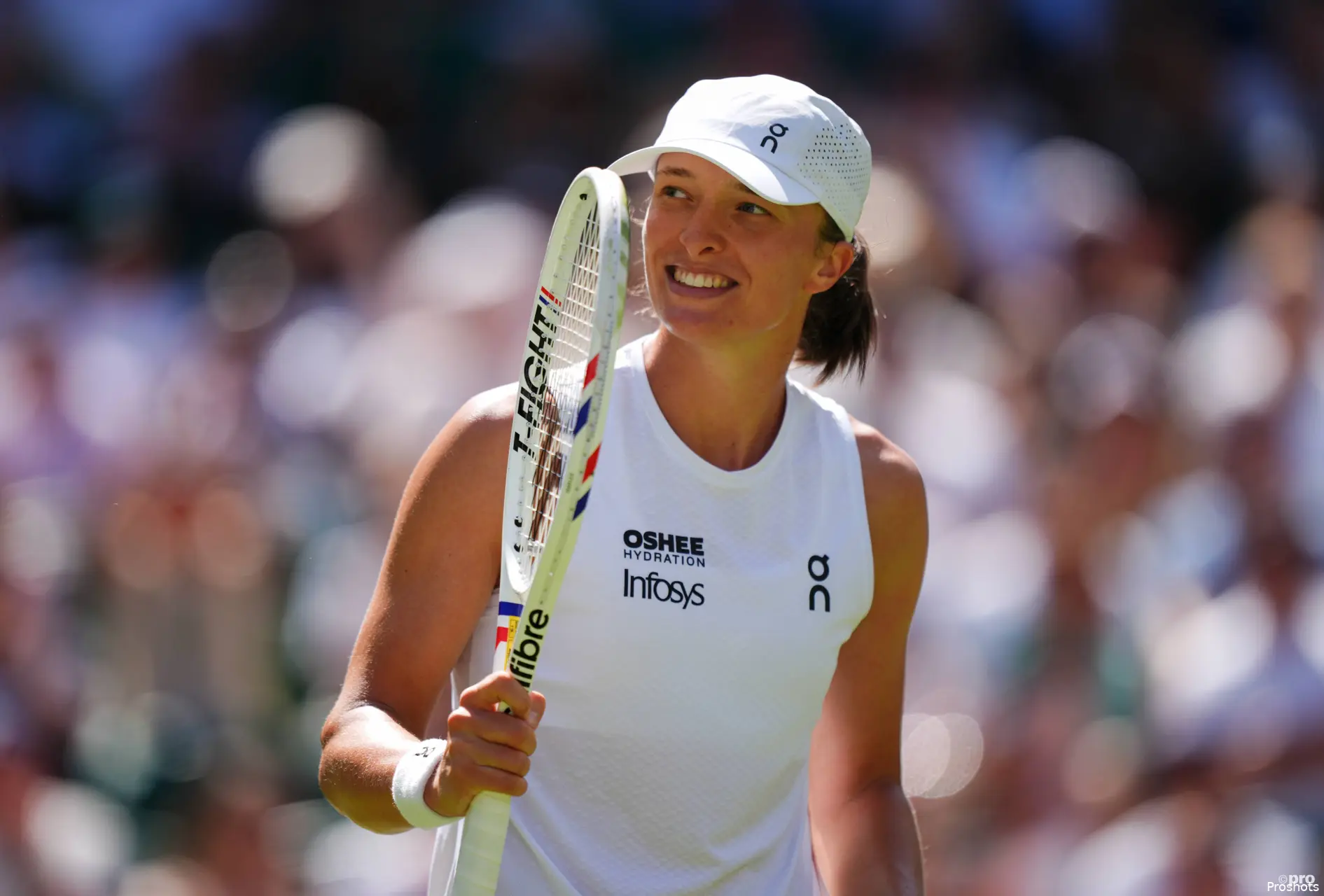 Iga Swiatek holds racquet.