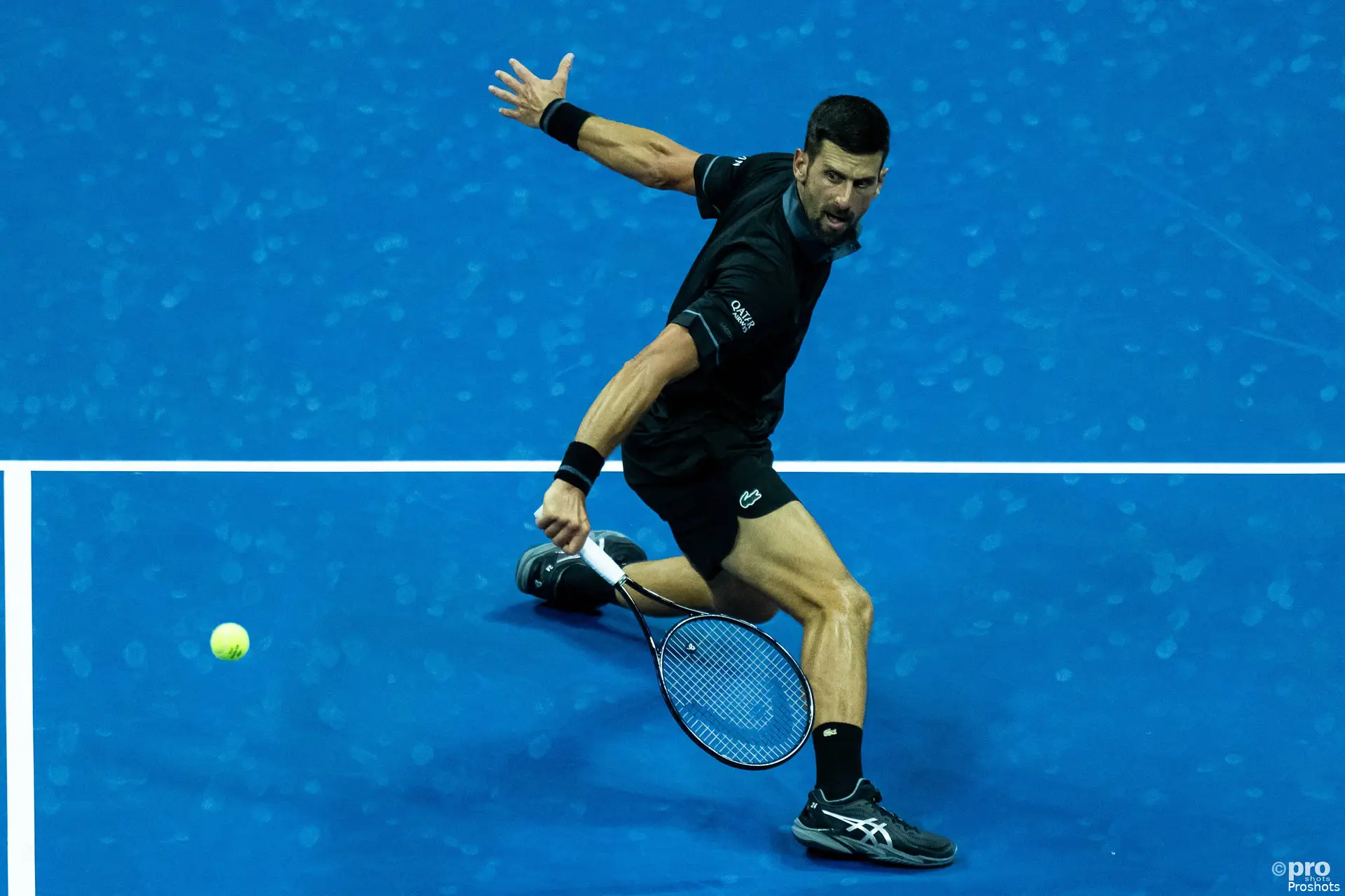 Novak Djokovic sliding while hitting one-handed backhand