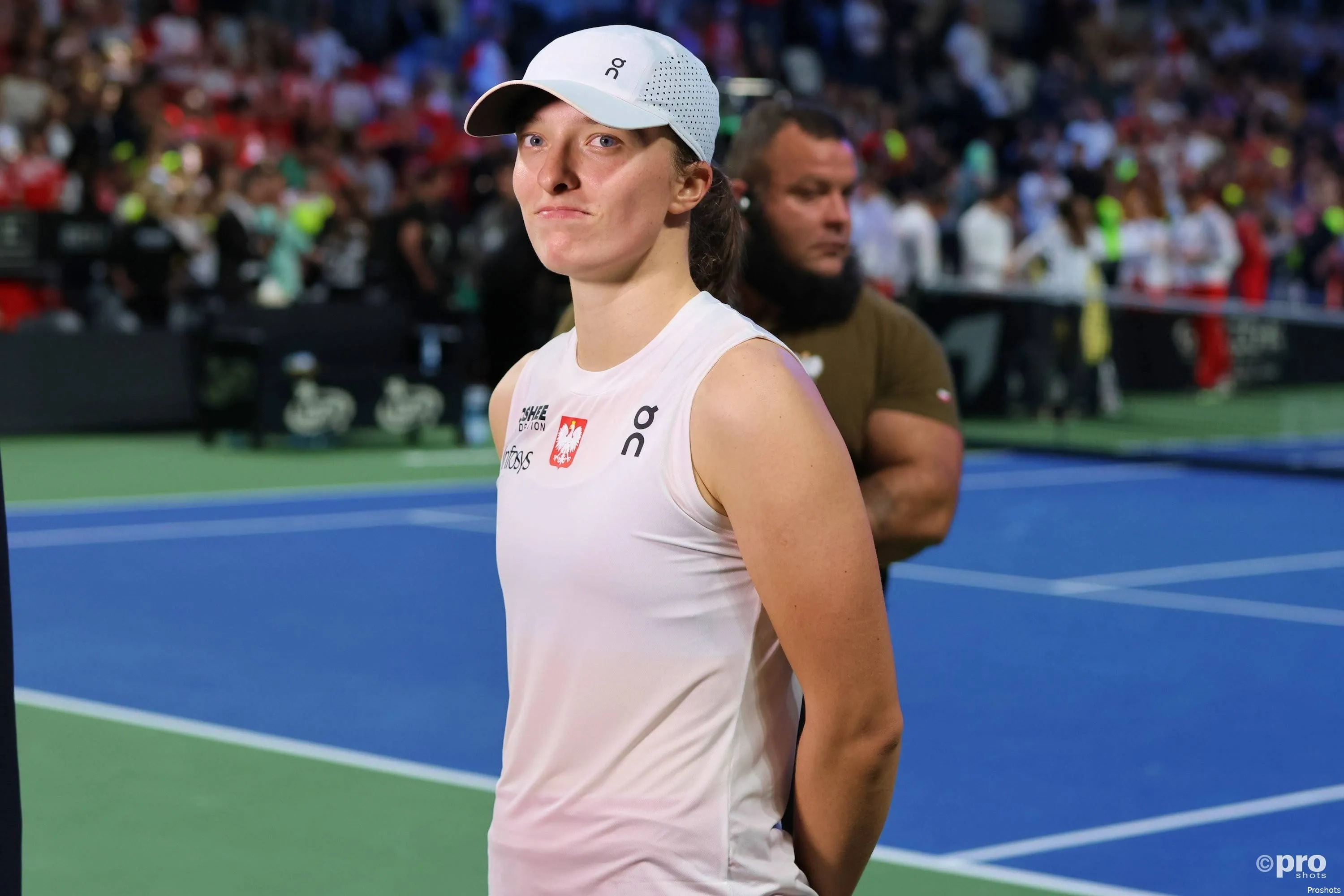 Iga Swiatek poses next to the court during the 2025 BJK Cup