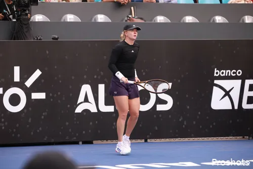 Francesca Jones stands on the baseline.