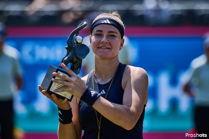 Muchova holds trophy aloft.