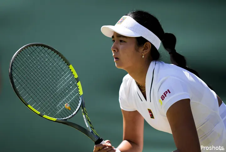 Alexandra Eala holds racquet waiting to return.