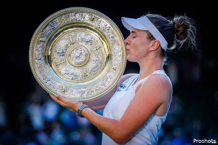 Noskova kisses Wimbledon trophy.