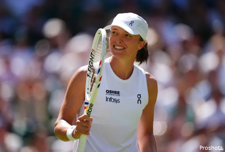 Iga Swiatek holds racquet.