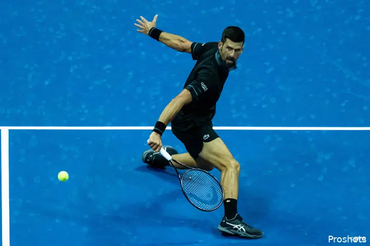 Novak Djokovic sliding while hitting one-handed backhand