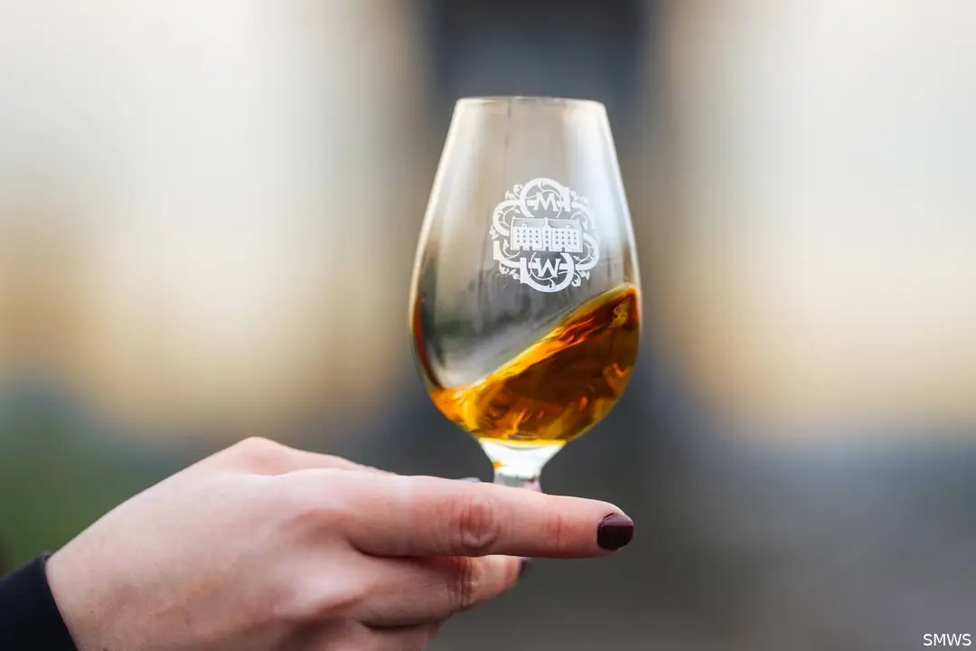 Whisky in glass raised to toast the start of the new whisky season on Calton Hill, Edinburgh for the Whisky Equinox
