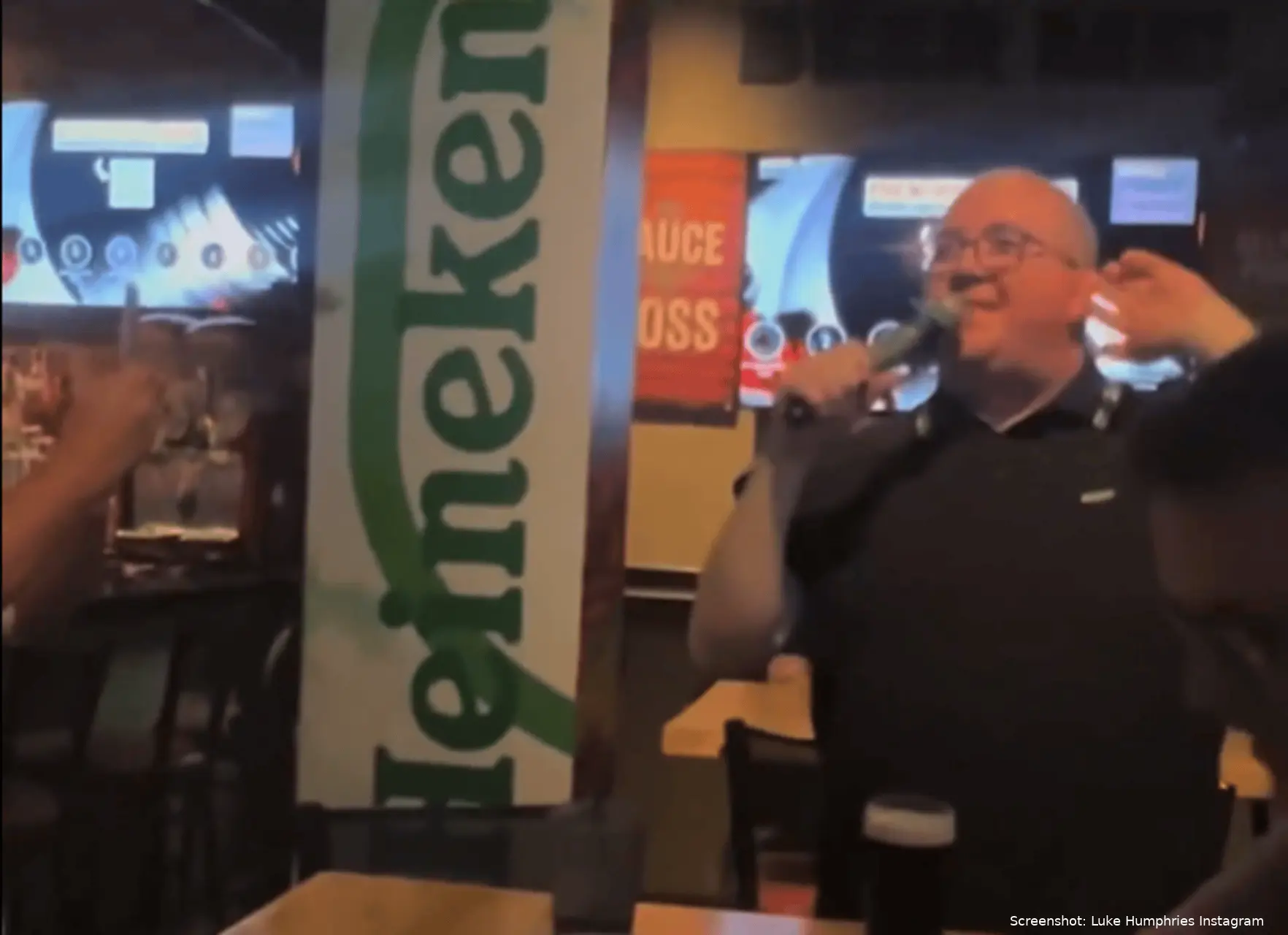 Stephen Bunting leads a karaoke singalong in a pub