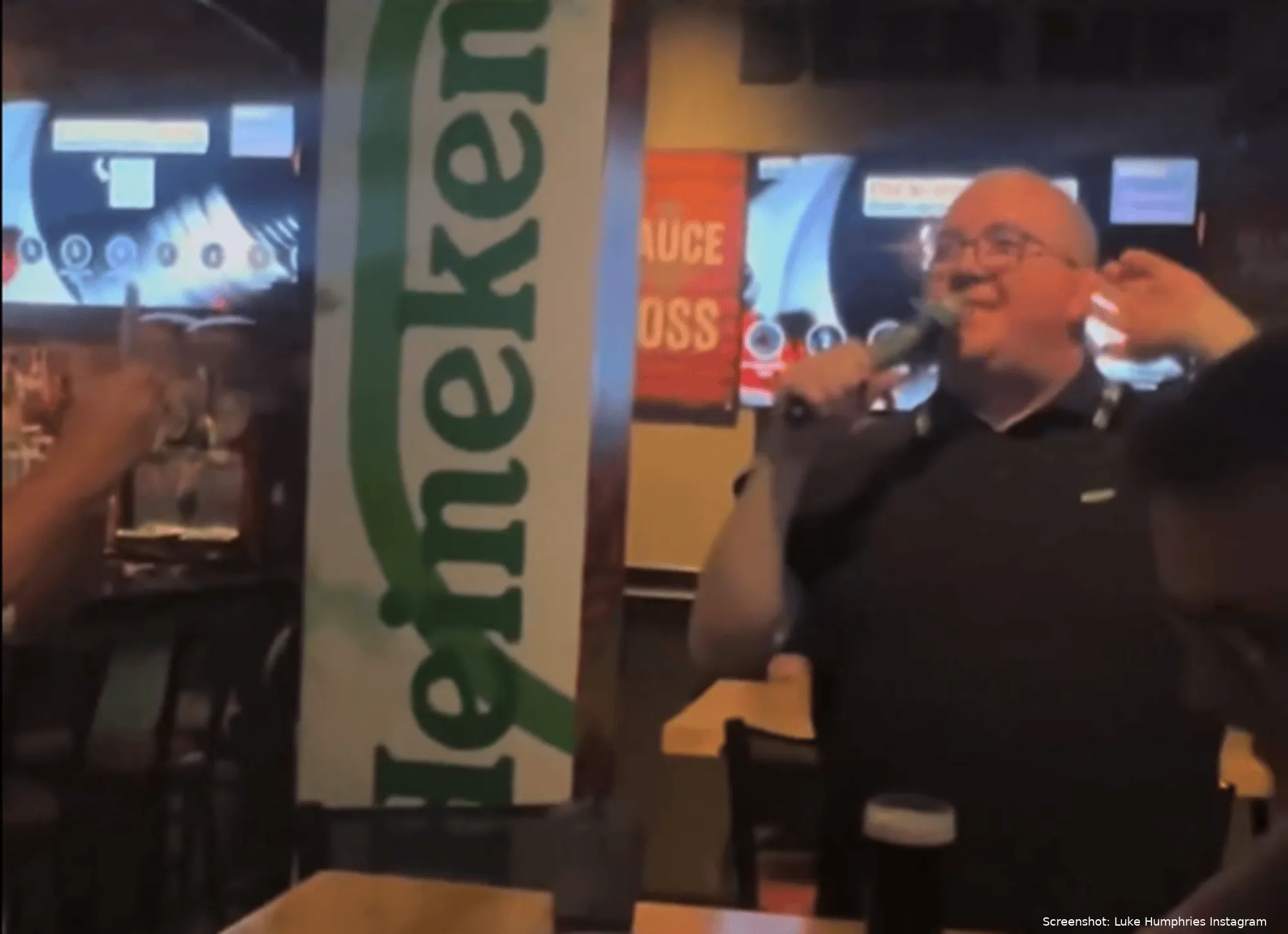 Stephen Bunting leads a karaoke singalong in a pub
