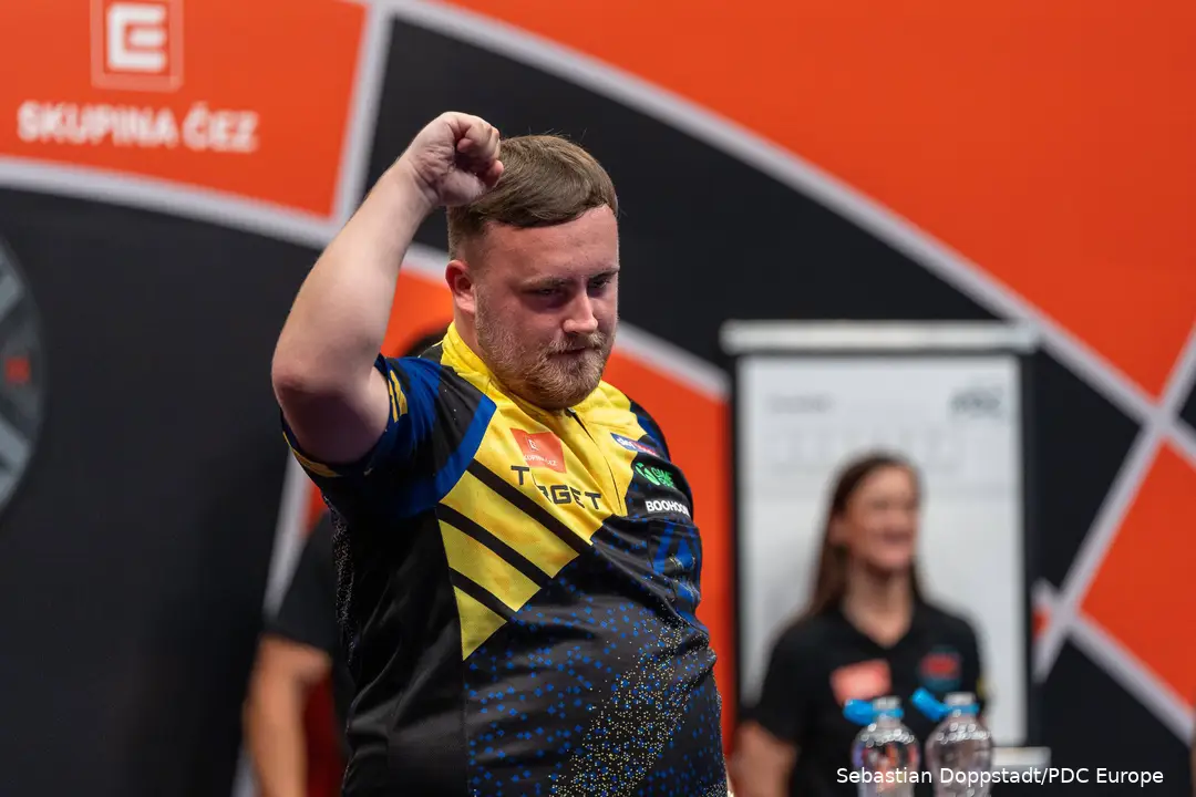 Luke Littler holds fist in the air.