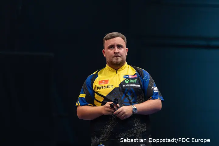 Luke Littler looks on.