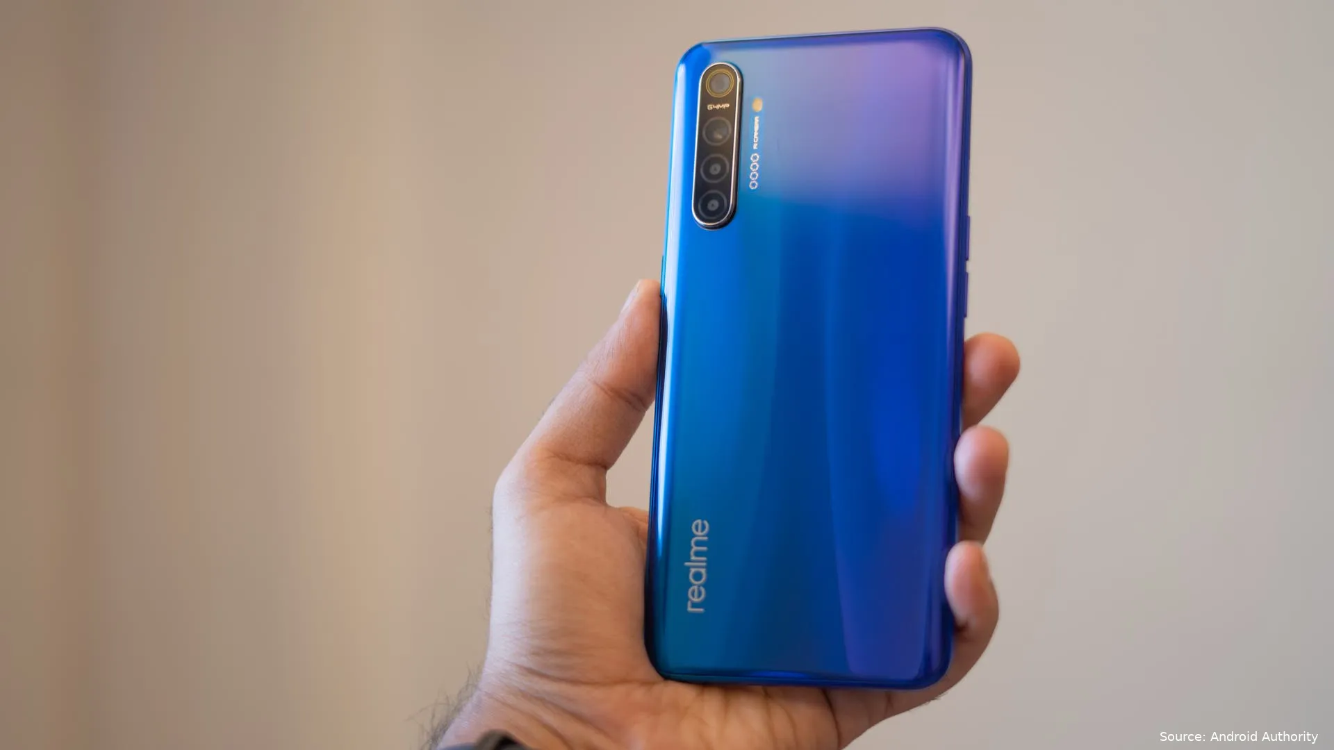 realme xt in hand with back panel and gradient