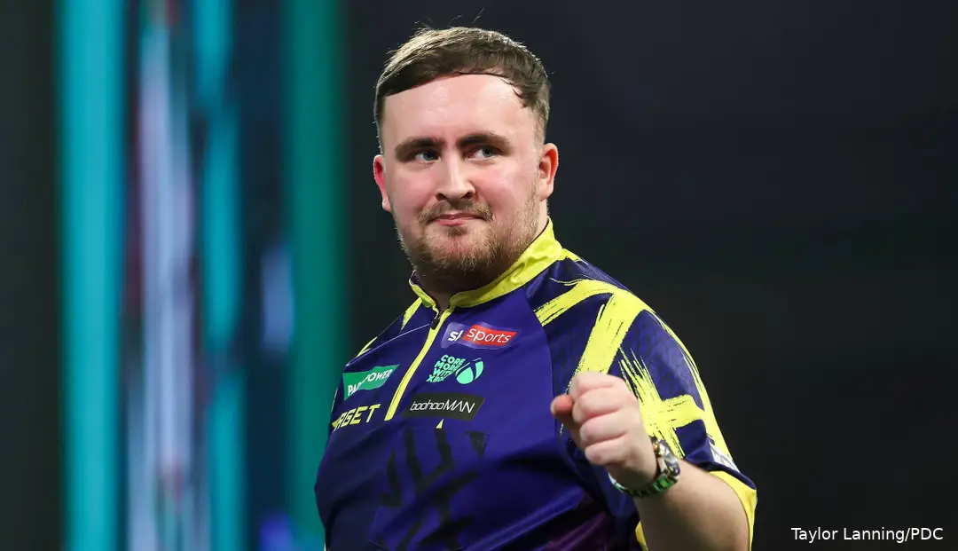 Luke Littler raises his fist on stage at PDC World Darts Championship.