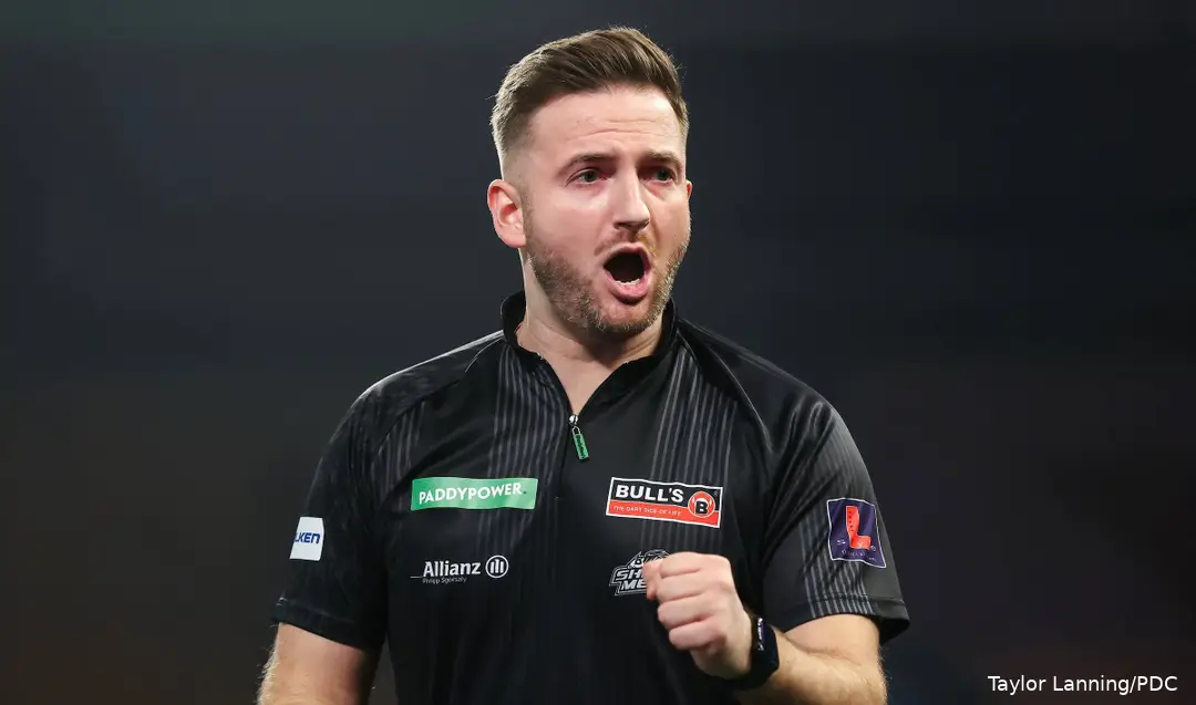 Arno Merk viert met open mond het winnen van een leg