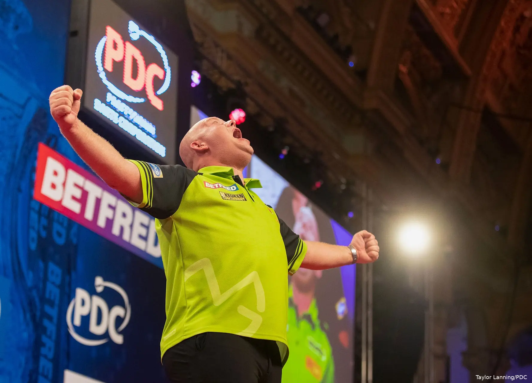 Michael van Gerwen celebrates with his arms spread wide.