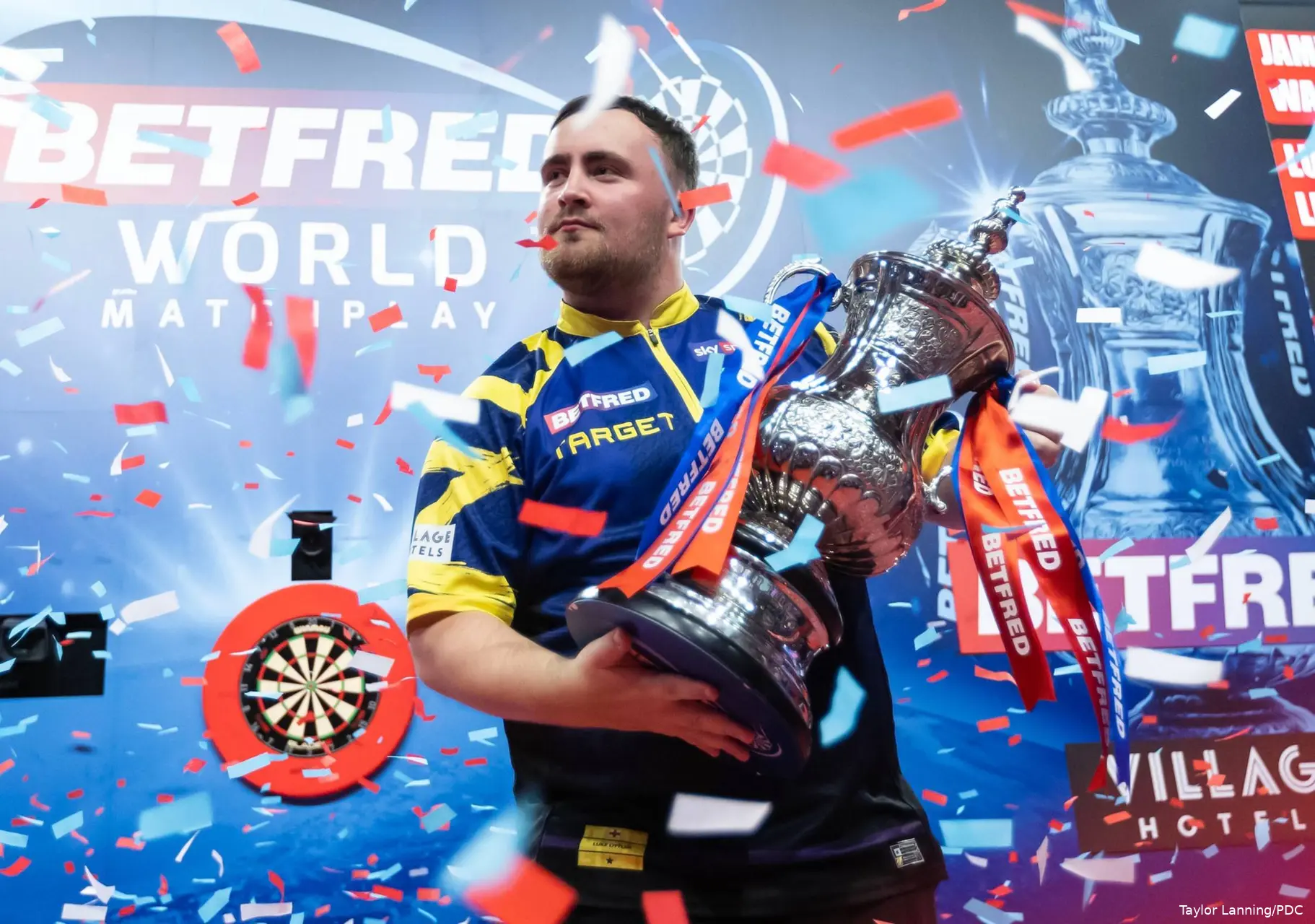 Luke Littler houdt de Phil Taylor Trophy vast