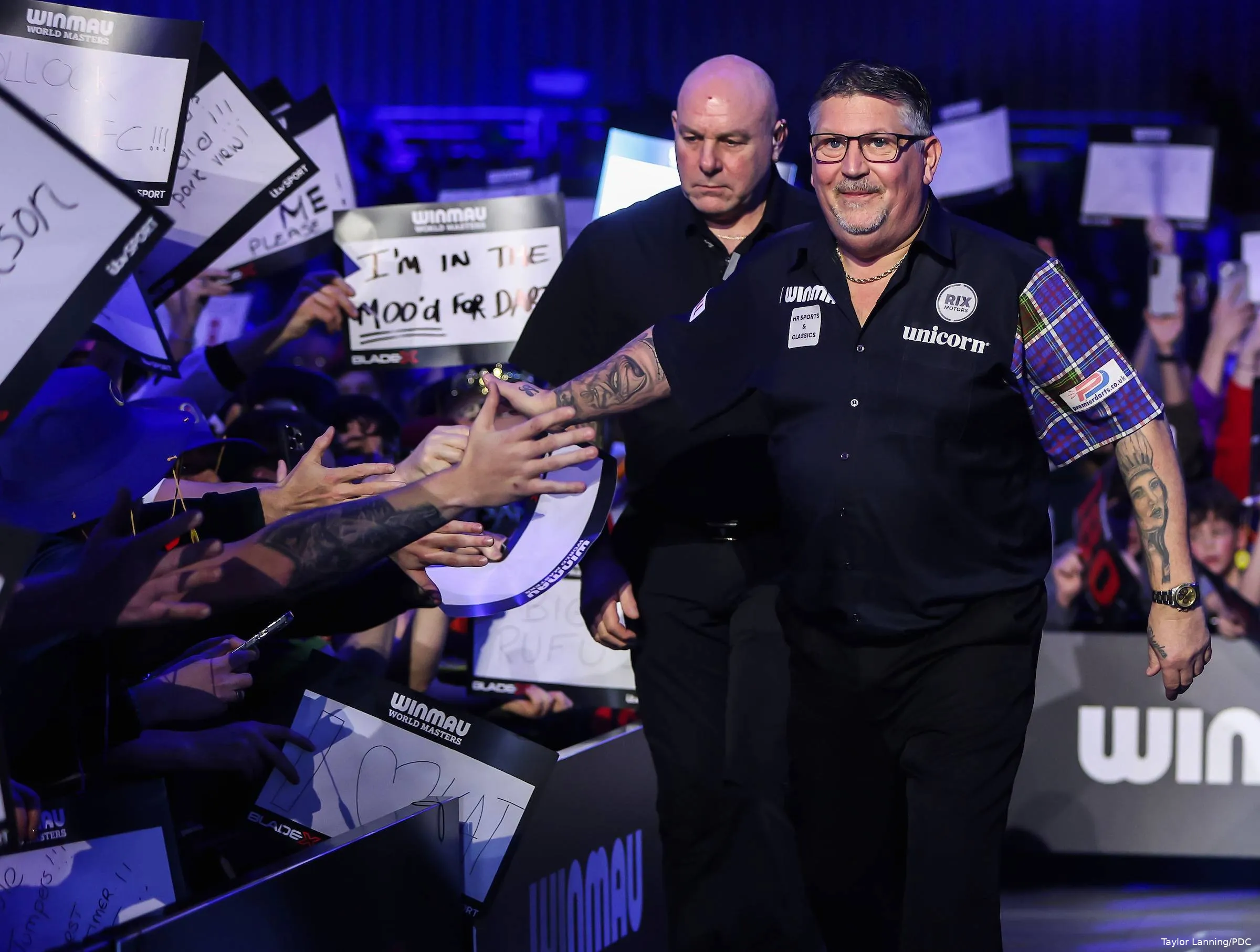 Gary Anderson touches fan hands.