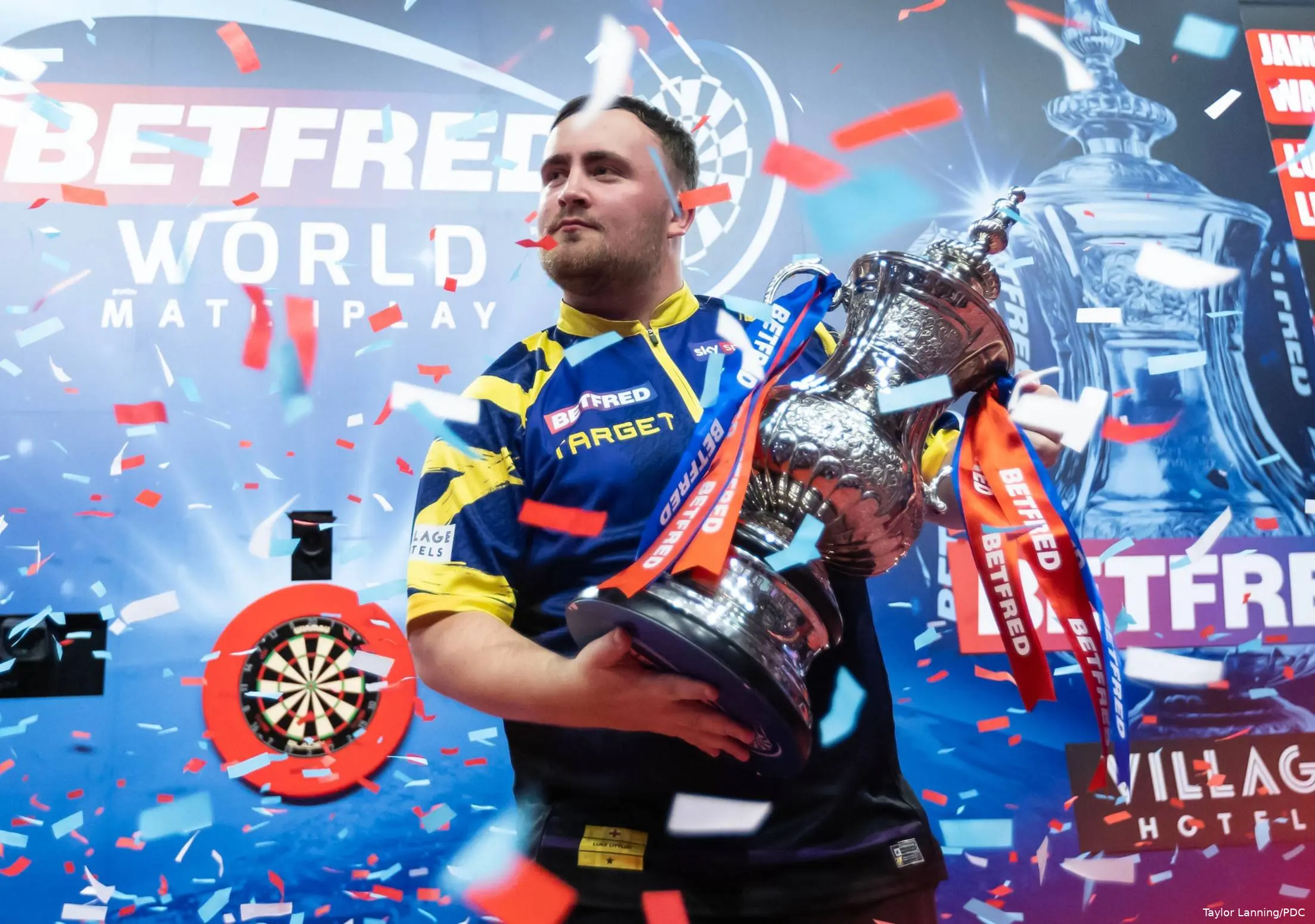 Luke Littler shows the trophy
