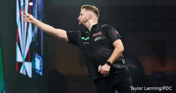 Arno Merk throws his darts using his hand towards the board.