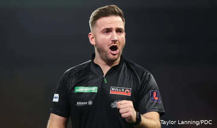 Arno Merk viert met open mond het winnen van een leg