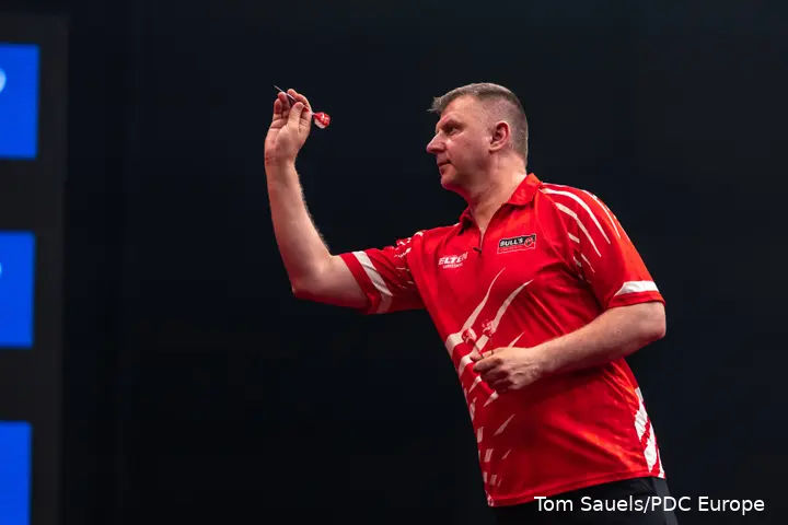 Krzysztof Ratajski throws dart.