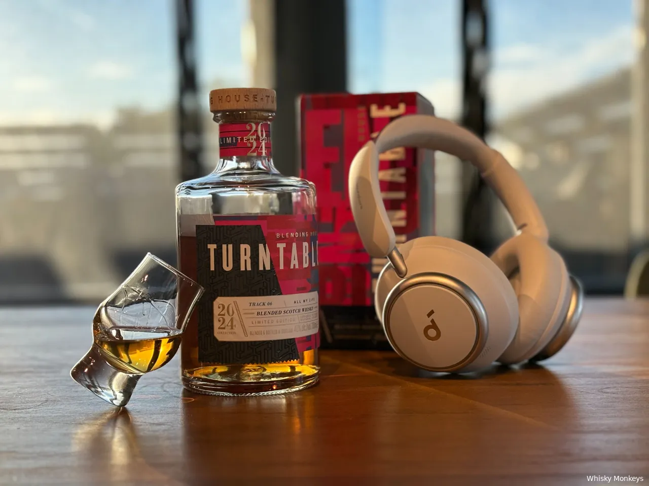 Turntable track 06 all my life whisky blended whisky met een koptelefoon en een glas op een tafel