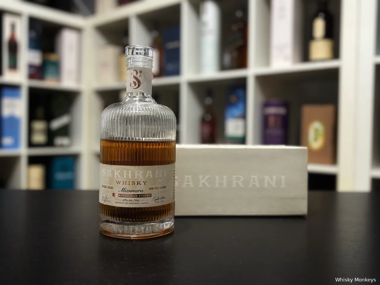 Sakhrani Mizunara Japanese Oak Finish whisky in front of a whisky cabinet