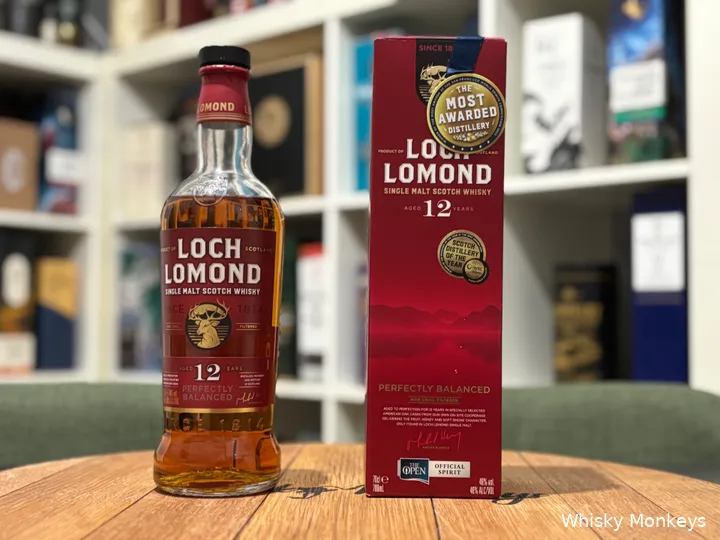 Loch Lomond 12 Year Old bottle and box on a barrel lid in front of a whisky cabinet