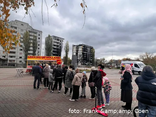 Mensen in de rij voor gebombardeerde woningen