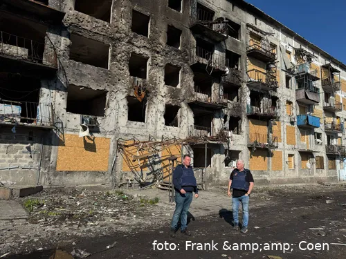 Franky en Coen bij een gebouw dat volledig kapot is