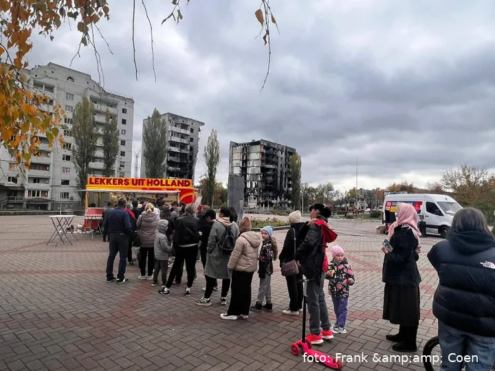 Mensen in de rij voor gebombardeerde woningen