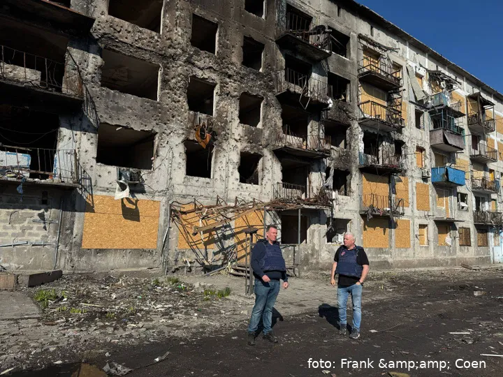 Franky en Coen bij een gebouw dat volledig kapot is
