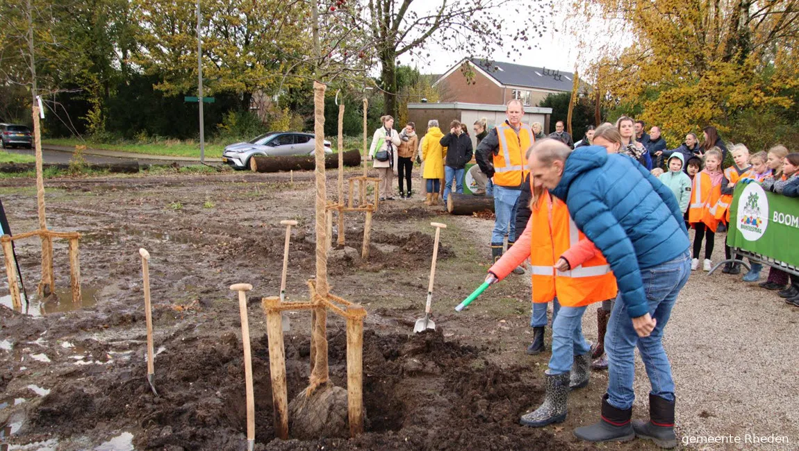 wethouder klomberg en kind plaatsen tijdcapsule onder boom