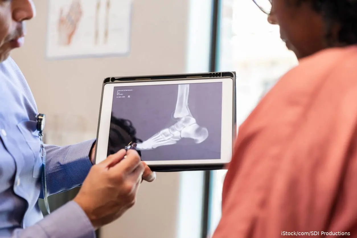 Physician and patient reviewing ankle X-ray