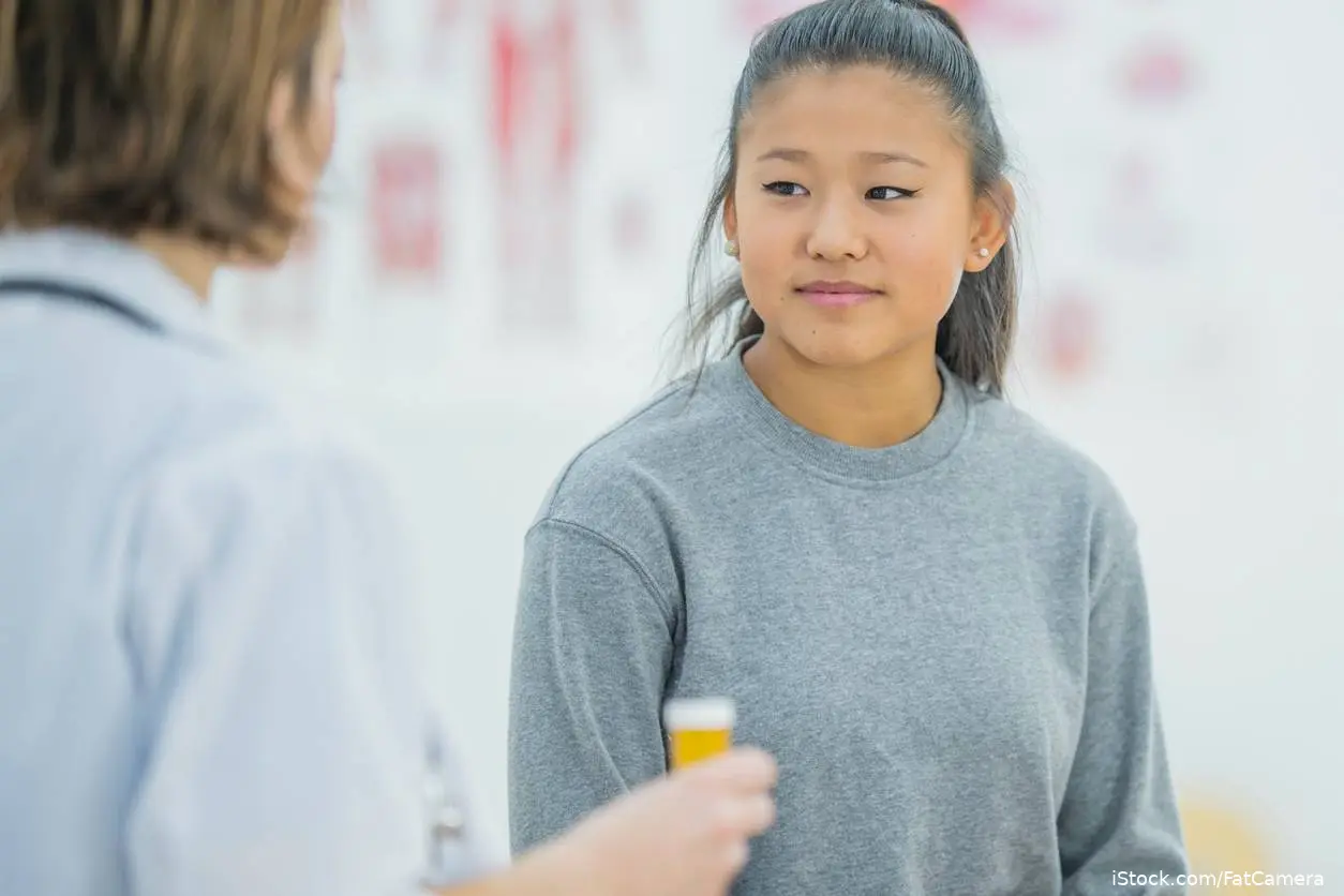 teen asian patient getting med from doctor in office